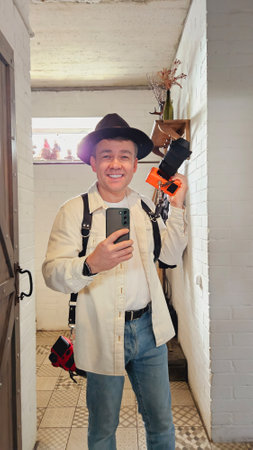 Smiling man with cameras on straps unloading for professional photographersの写真素材