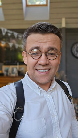Portrait of a middle-aged man in funny round little glasses.