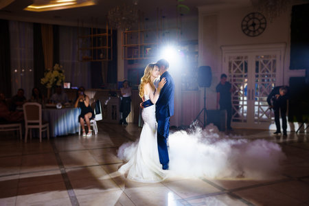 Beautiful and happy bride and groom dancing first dance at wedding.の写真素材
