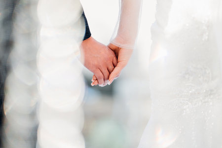 The bride and groom holding hands at the wedding ceremony venueの写真素材