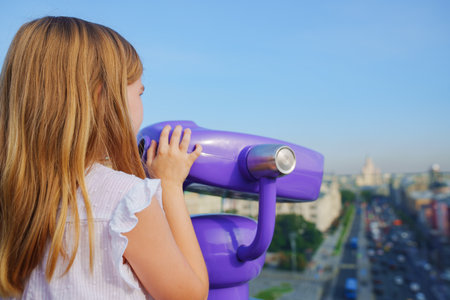 a teenage girl looks into the Binoscope from the observation deck at a height.の写真素材