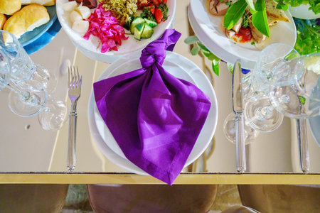 Beautiful festive table setting with purple napkins.