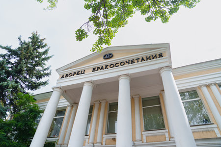 A sign on the building of the Wedding Palace with columns against the sky.のeditorial素材
