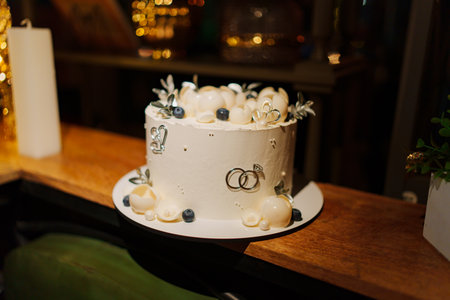 White wedding cake decorated with chocolate flowers and blueberriesの写真素材
