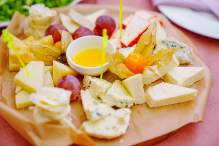 Plate with cheese platters, honey and fruit.の写真素材