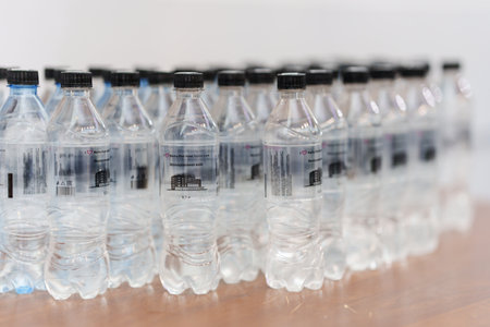 Plastic bottles with black lid for clean drinking water on the table.