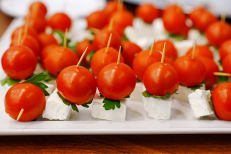 Canapes of cheese and cherry tomatoes with herbs.の写真素材