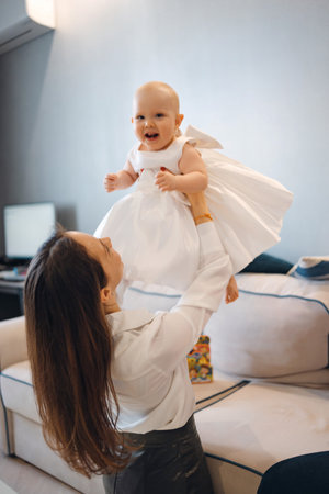 cheerful baby daughter in an elegant dress with her motherの写真素材