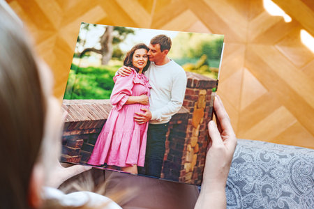 woman is holding a photo book with a pregnancy photo shootの写真素材