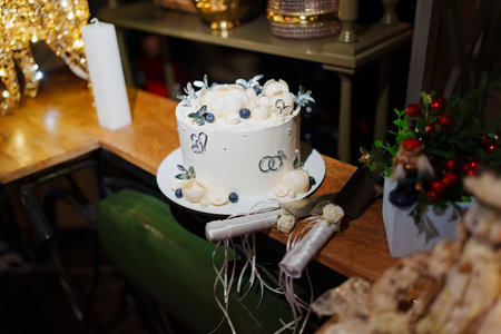 White wedding cake decorated with chocolate flowers and blueberries