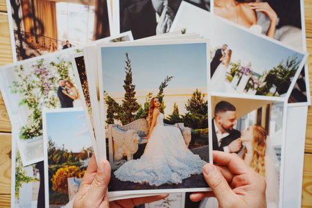 Mens hands put on the table and show wedding photos.の写真素材