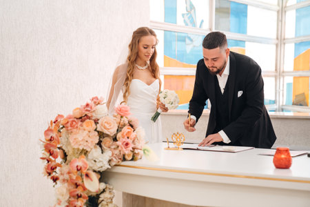 The bride and groom sign in the registry office.の写真素材