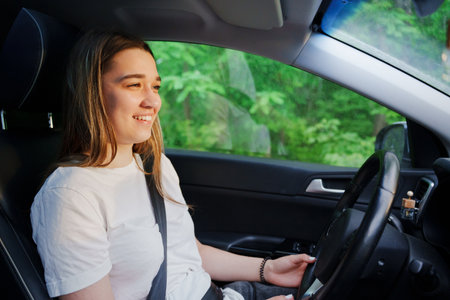 A young girl is driving a car. an inexperienced driver.