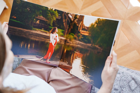 woman is holding and flipping through a photo book with a pregnancy photo shootの写真素材