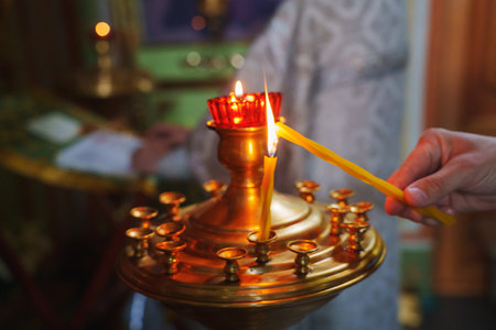 A gilded church candlestick with burning candles and an oil lamp.の写真素材