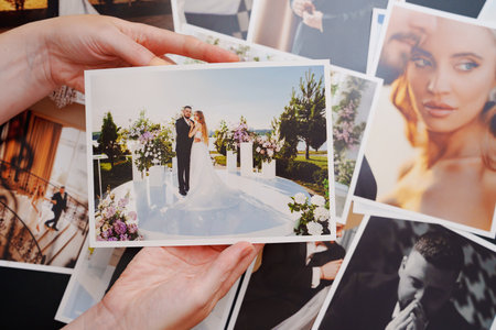 womens hands put on the table and show wedding photos.の写真素材