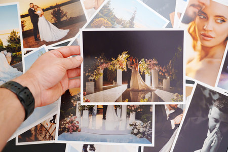 Mens hands put on the table and show wedding photos.の写真素材