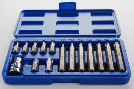 A set of single-sided chrome steel bits in a blue plastic box