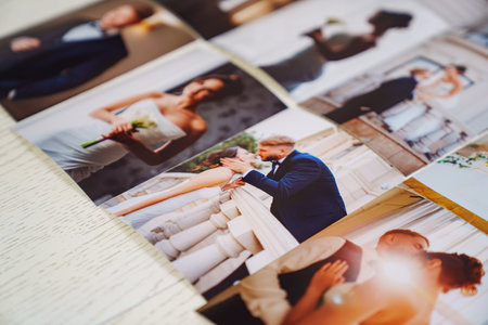 Printed wedding photos laid out on a wooden surface.の写真素材