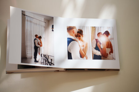 an open photo book with wedding photos on a white tableの写真素材