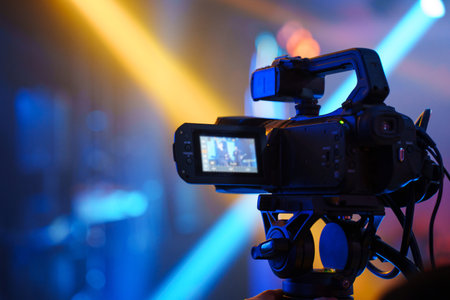 A professional videographer is filming a banquet hall event.