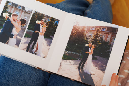 Female hands flipping through a photo book with wedding photosの写真素材