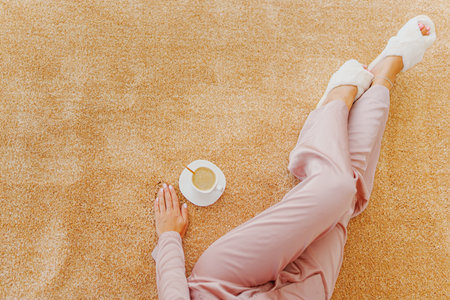 faceless woman with a cup of coffee on the beige Interior pile carpet made of polypropylene. Long fibers form a high pile. pleasant lint texture, softness and hypoallergenicity.の写真素材