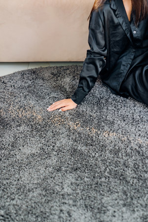 a woman's hand touching the gray Interior pile carpet. Long fibers form a high pile. pleasant lint...