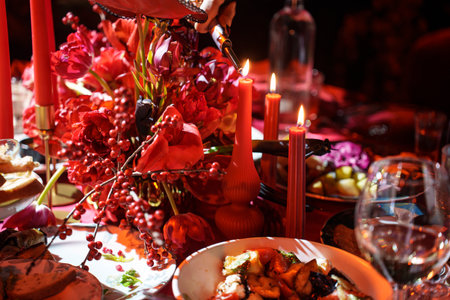 three burning candles on the banquet table in the dark. atmosphere of romance and celebration.の写真素材