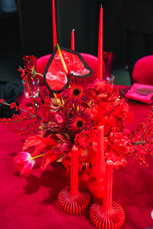 red flowers and candles on the banquet table in the dark. atmosphere of romance and celebration.の写真素材