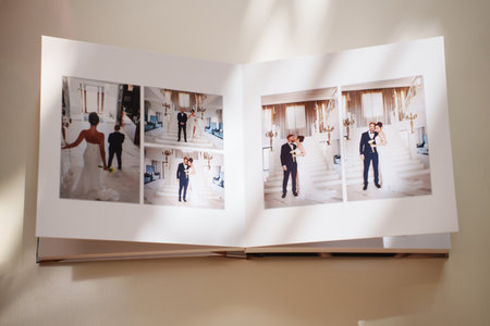 an open photo book with wedding photos on a white tableの写真素材