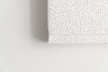 corner of book in white leather cover on white table. binding for photo albumの写真素材