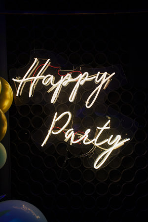 Happy Party Lettering LED Strip Light on Black Background with Balloons. festive decorations.の写真素材