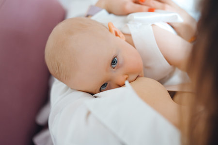 Mom feeds baby daughter with breast milk.