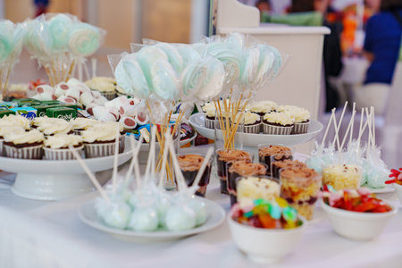 Served table with gummies, cupcakes, cakes and desserts.の写真素材