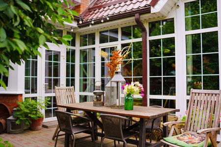 wooden table with lanterns and dried flowers. The yard in the house.
