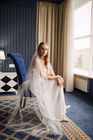 The bride in simple beautiful elegant wedding dress sitting on a chairの写真素材