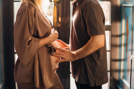 without faces. A Man gently touches pregnant woman's belly. Happy family. the happiness of waiting for the birth of a baby. healthy parents and children. treatment and prevention.の写真素材