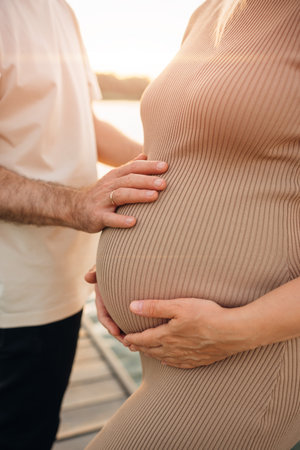 without faces. A man gently hugs a pregnant woman on the pier. Travel and sea cruises during pregnancy. A healthy and happy family.の写真素材