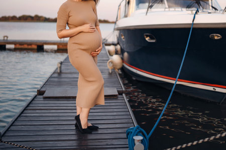 without face. A pregnant woman on the pier. Travel and sea cruises during pregnancy. A healthy and happy family.の写真素材