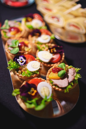 tartlets with pate and salad garnished with flowers. Delicious appetizers for a buffet. A variety of festive menus.の写真素材