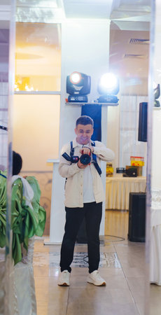 Selfie of a male photographer in the mirror of a banquet hall. The work of a professional...