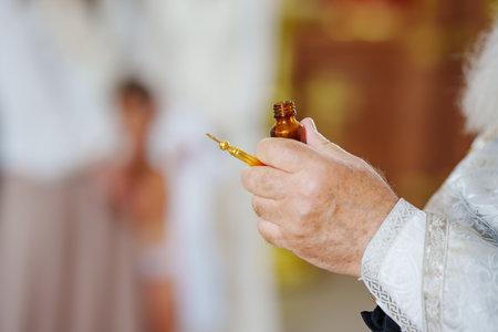 The priest performs chrismation at the sacrament of baptism. hands of a priest. Orthodox traditions.の写真素材