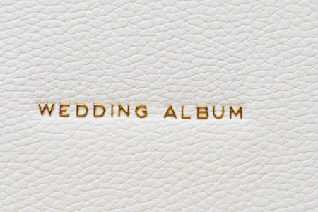 The inscription Wedding Album in gold letters on the white leather cover of the book. storing printed photos in a book.の写真素材