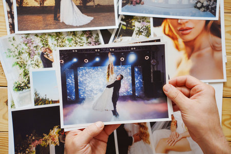 Mens hands put on the table and show wedding photos.