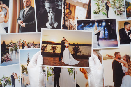 hands in white gloves and Beautiful printed wedding photos.の写真素材