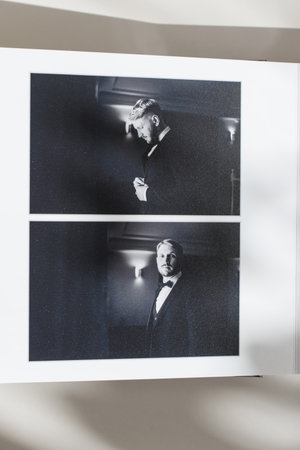 page of an open photo book with wedding photos on a white table