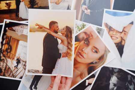 womens hands put on the table and show wedding photos.