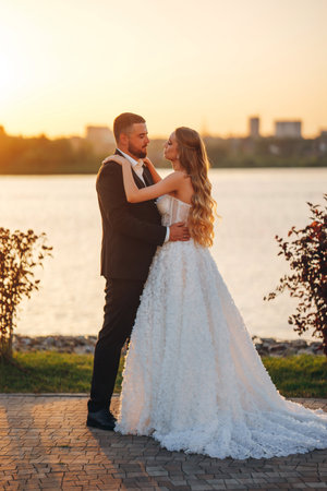 Gentle and happy bride and groom at sunset on the riverbank. Romantic.の写真素材