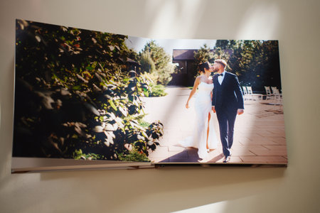 an open photo book with wedding photos on a white tableの写真素材